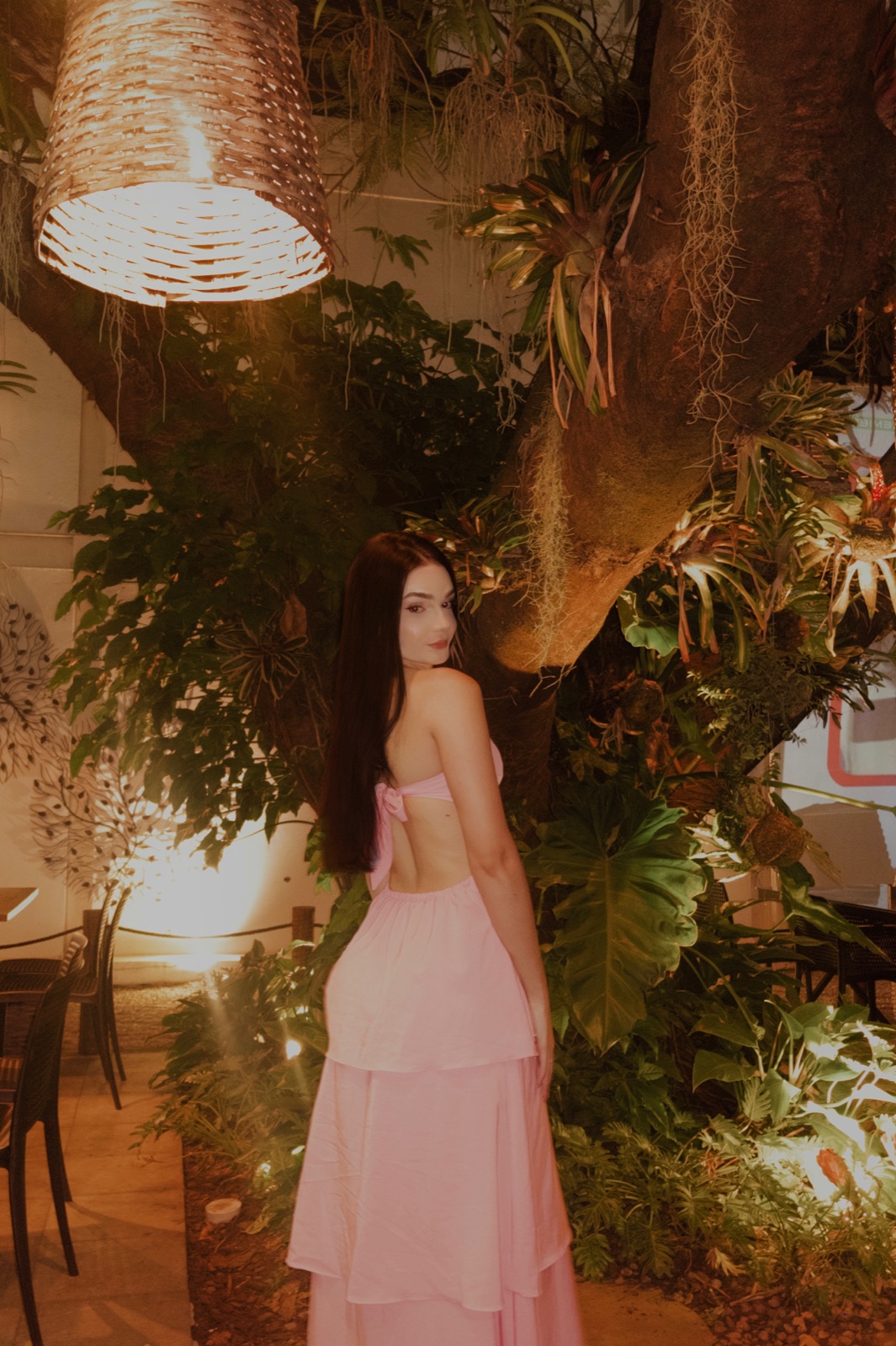 Sarah in a pink dress in a warm garden setting